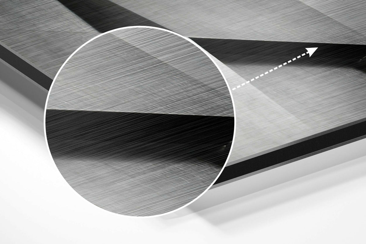 Magnified detail of the brushed metal grain showing through the gray geometric facade print