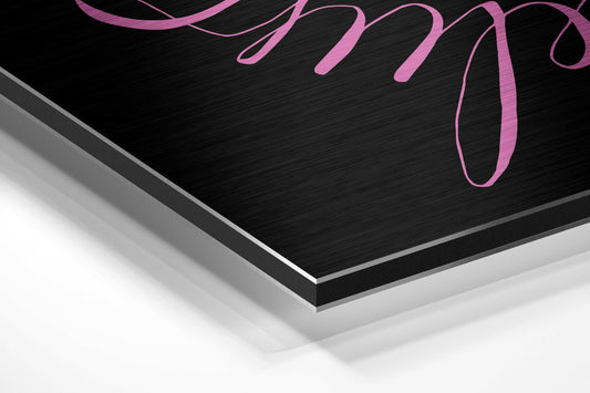 Always Believe pink lettering quote brushed aluminum panel corner close-up showing the brushed metal grain