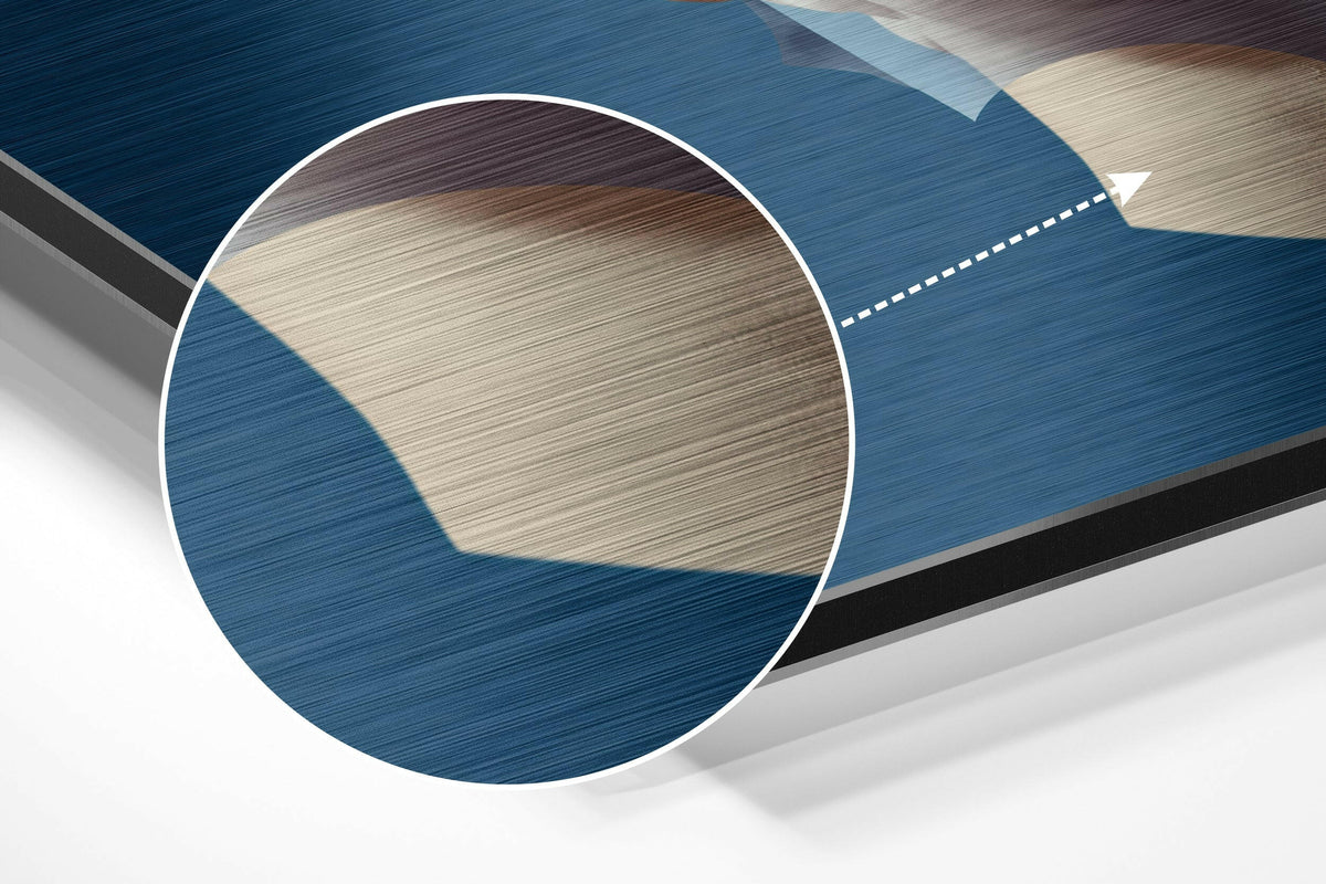 Magnified detail of the brushed metal grain showing through the blue statue head with tan cut-out circles print