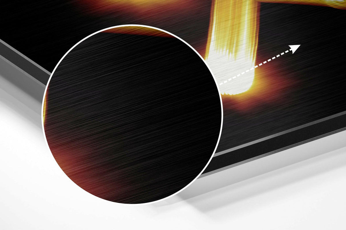 Magnified detail of the brushed metal grain showing through the Sagittarius zodiac sign in gold light print