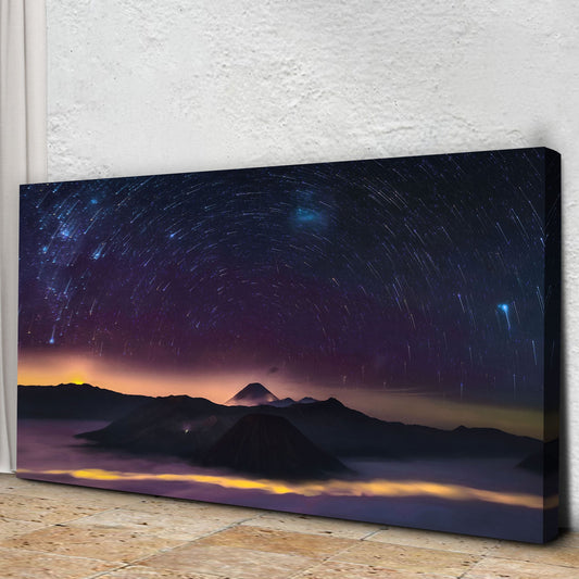 Star trails over a mountain peak canvas leaning at an angle on a stone floor