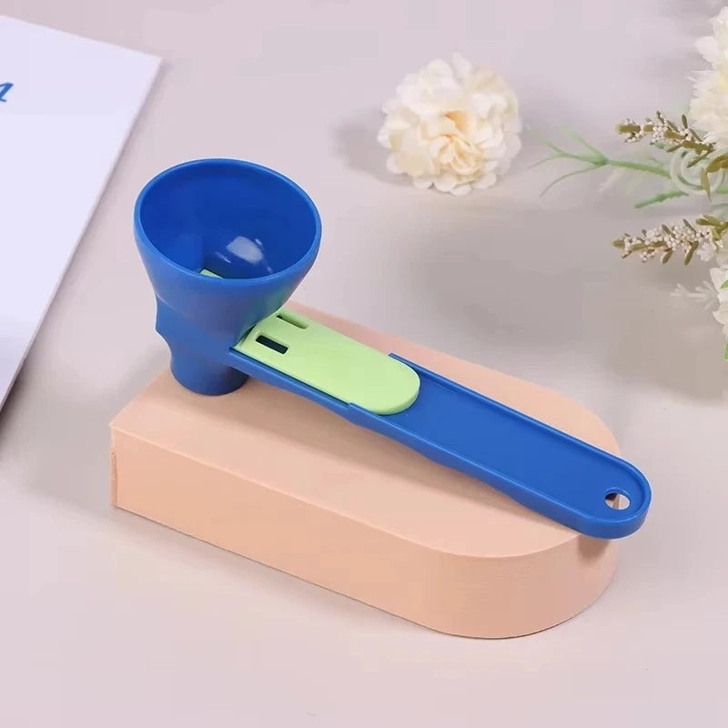 Blue and green measuring powder scoop on a beige block with flowers in the background