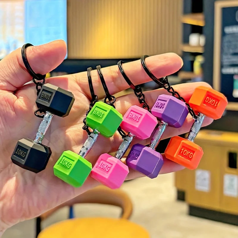 Collection of colorful 10KG dumbbell keychains in black, green, pink, purple, and orange fitness-themed charms