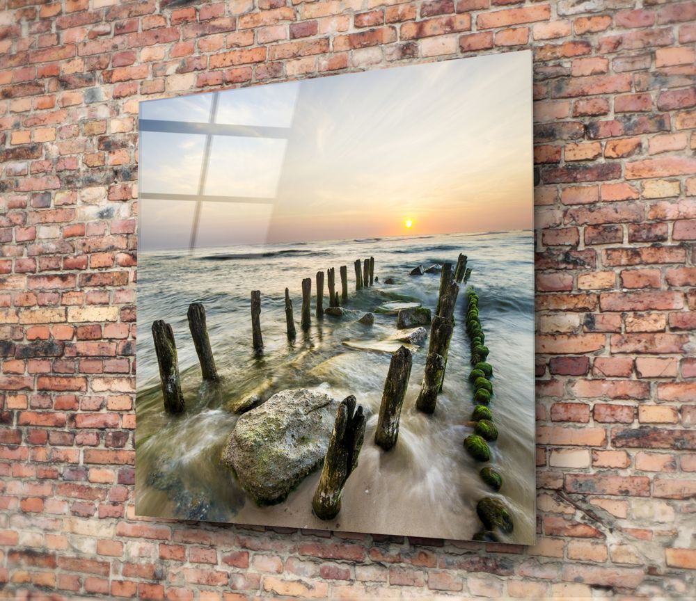 Mossy sea groynes glass wall art hung on a red brick wall