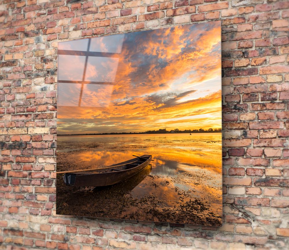 Blazing sunset sky and wooden boat square glass wall art on a red brick wall