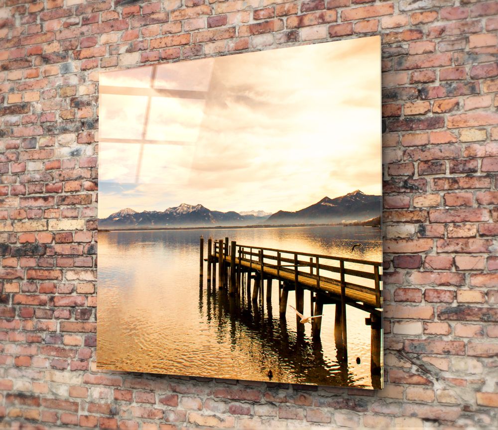 Wooden dock on a golden lake at sunset glass wall art on a red brick wall
