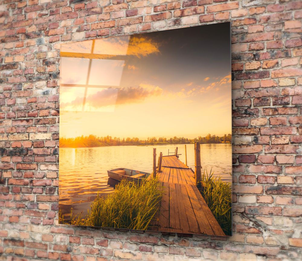 Golden lake dock with rowboat glass wall art hung on a red brick wall