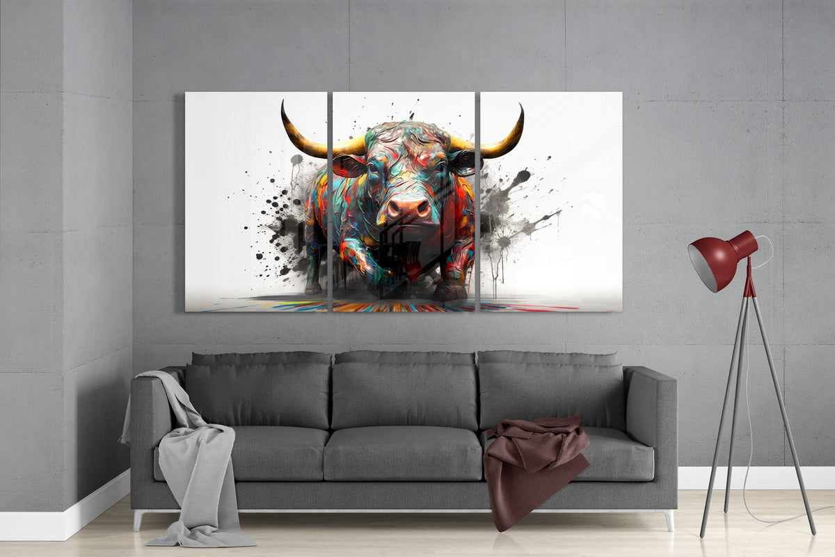 Paint splash bull 3-panel glass wall art set above a gray sofa beside a tripod floor lamp
