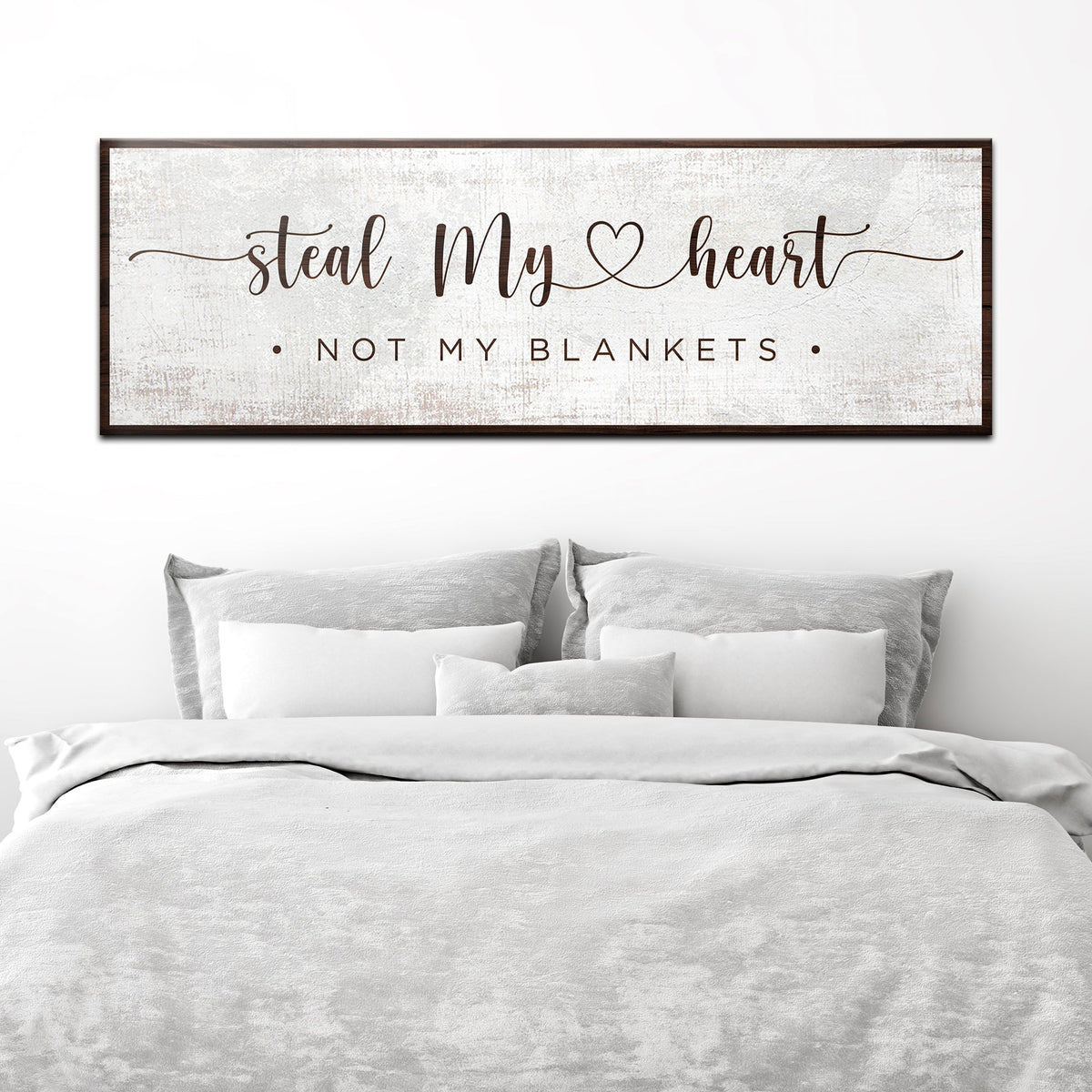Steal My Heart Not My Blankets canvas sign in the clean white style, above a bed with white linens