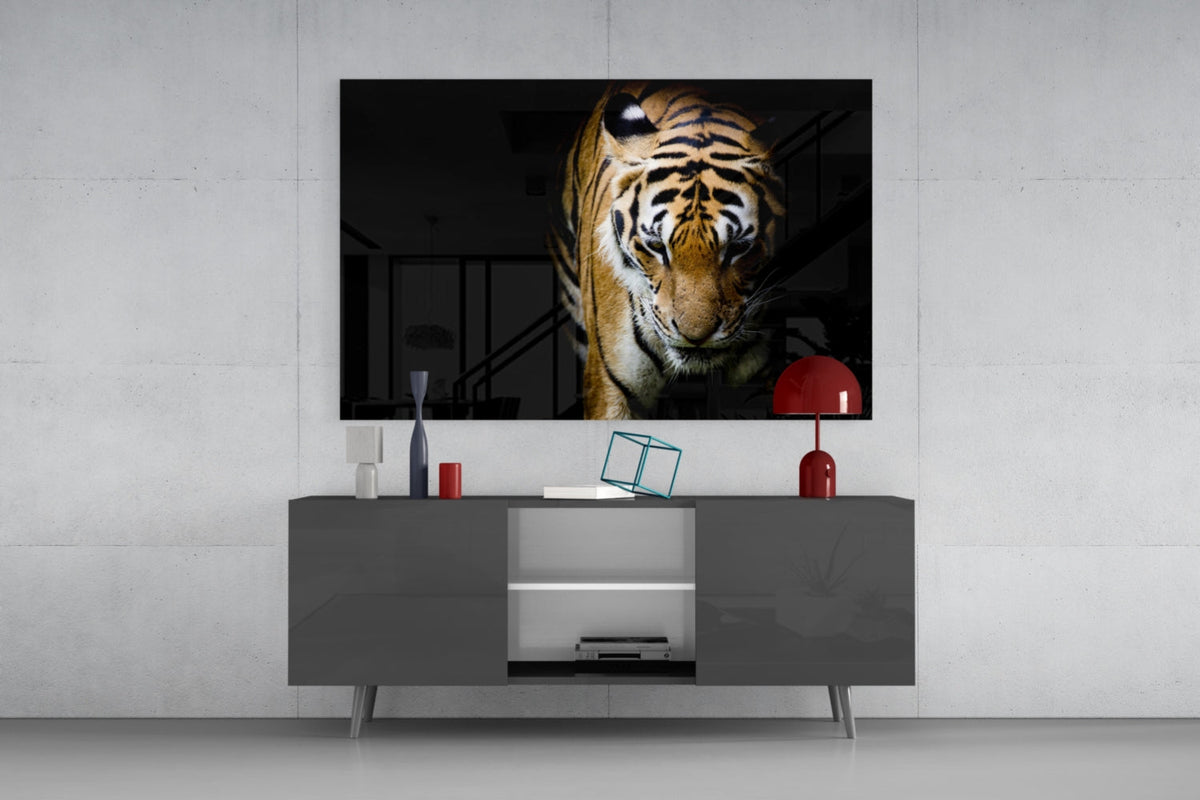 Tiger stepping out of the shadows glass wall art above a gray sideboard with a red table lamp