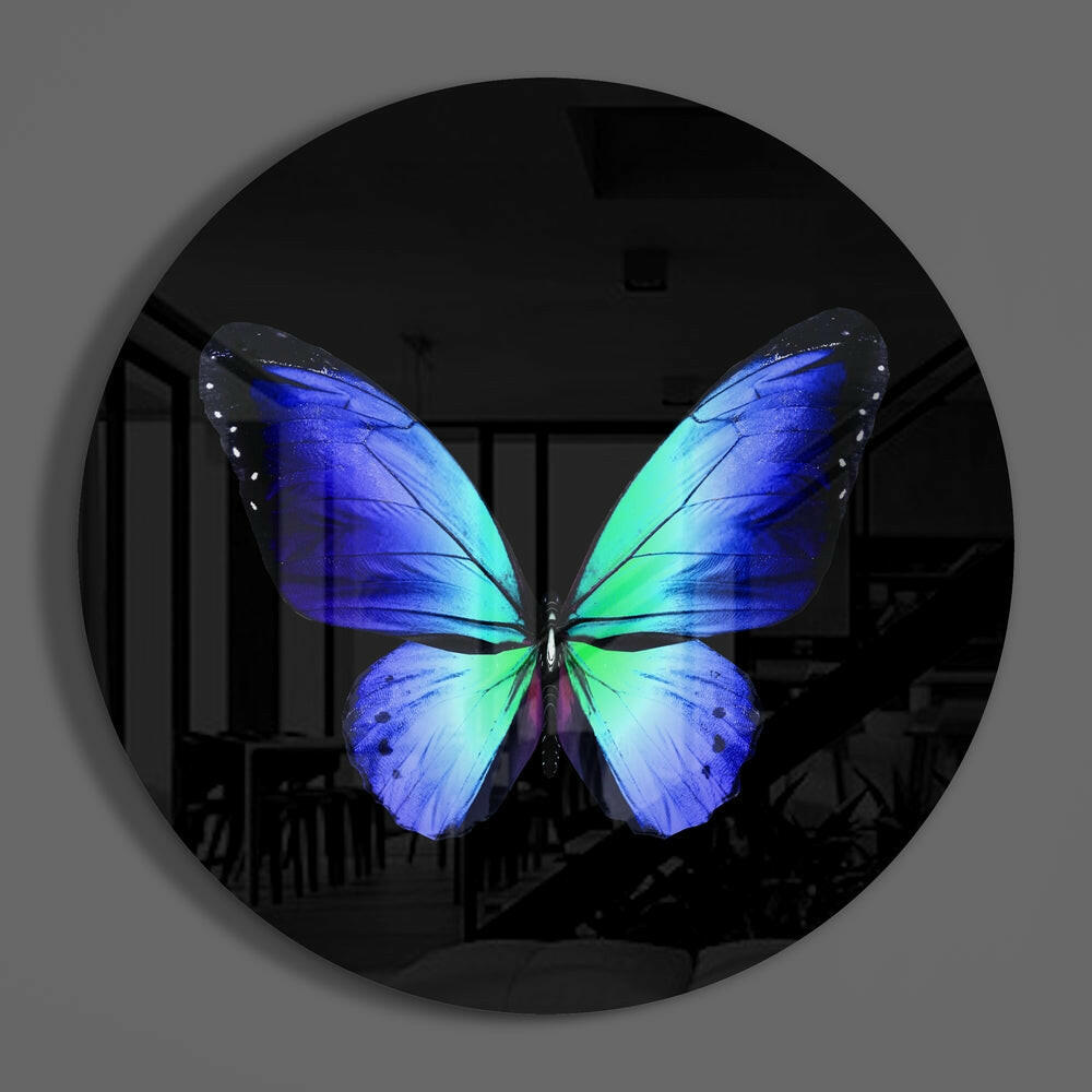 Blue green butterfly round glass wall art on a plain gray wall