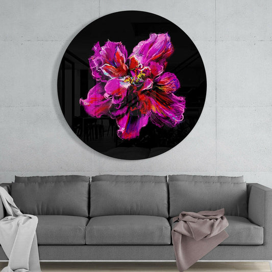 Magenta flower bloom round glass wall art above a gray sofa with draped throws on a pale concrete wall
