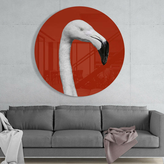 White flamingo on red round glass wall art above a gray sofa with white and pink throws