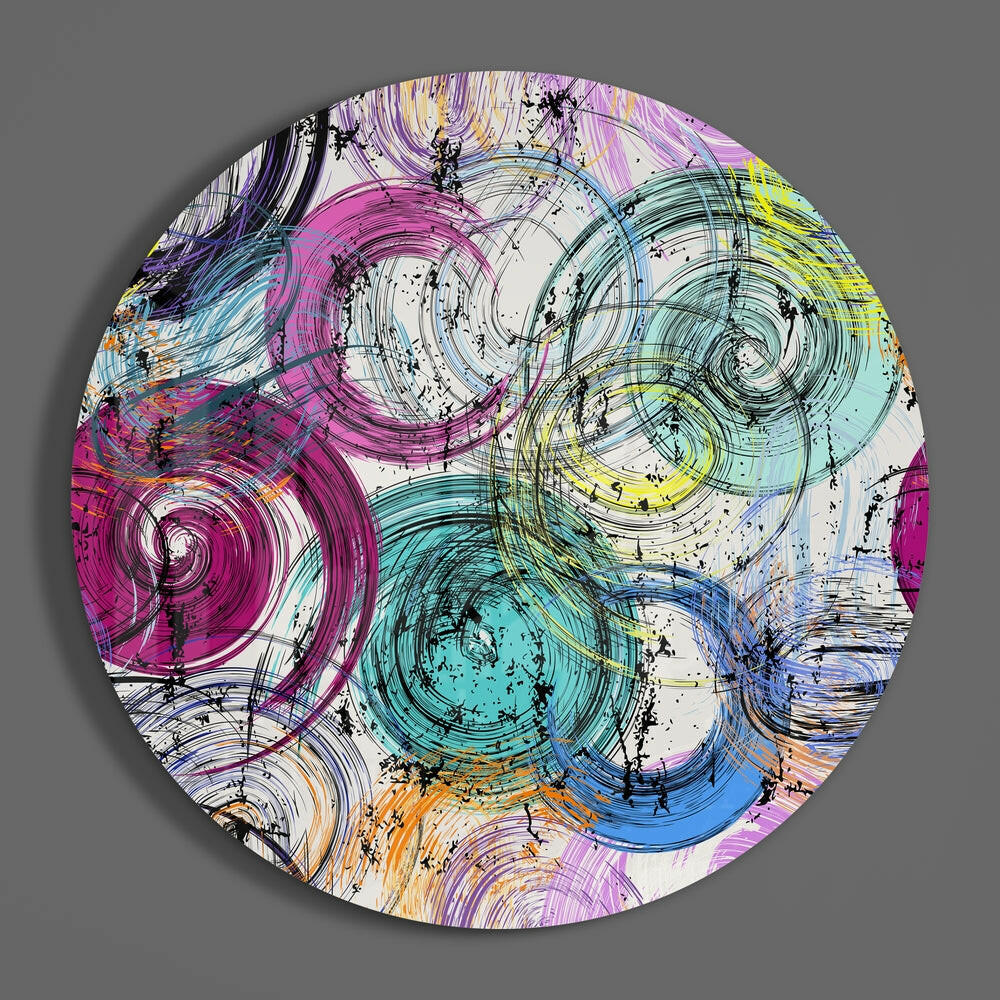Swirling ink circles round glass wall art hanging on a plain gray wall