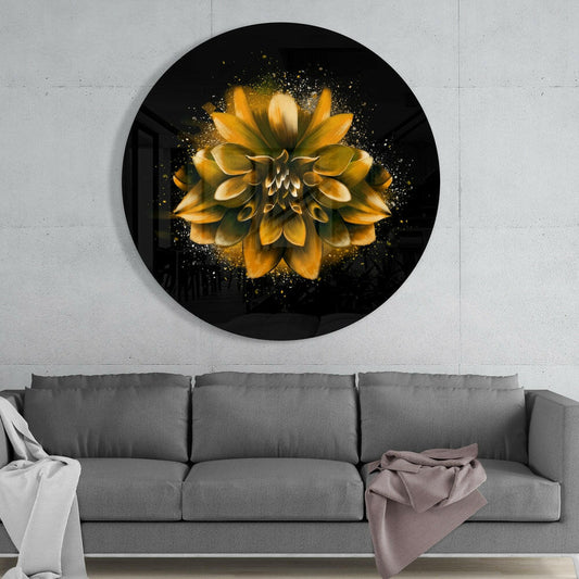 Golden splatter dahlia round glass wall art above a gray sofa with a white throw and a mauve blanket on a pale concrete wall