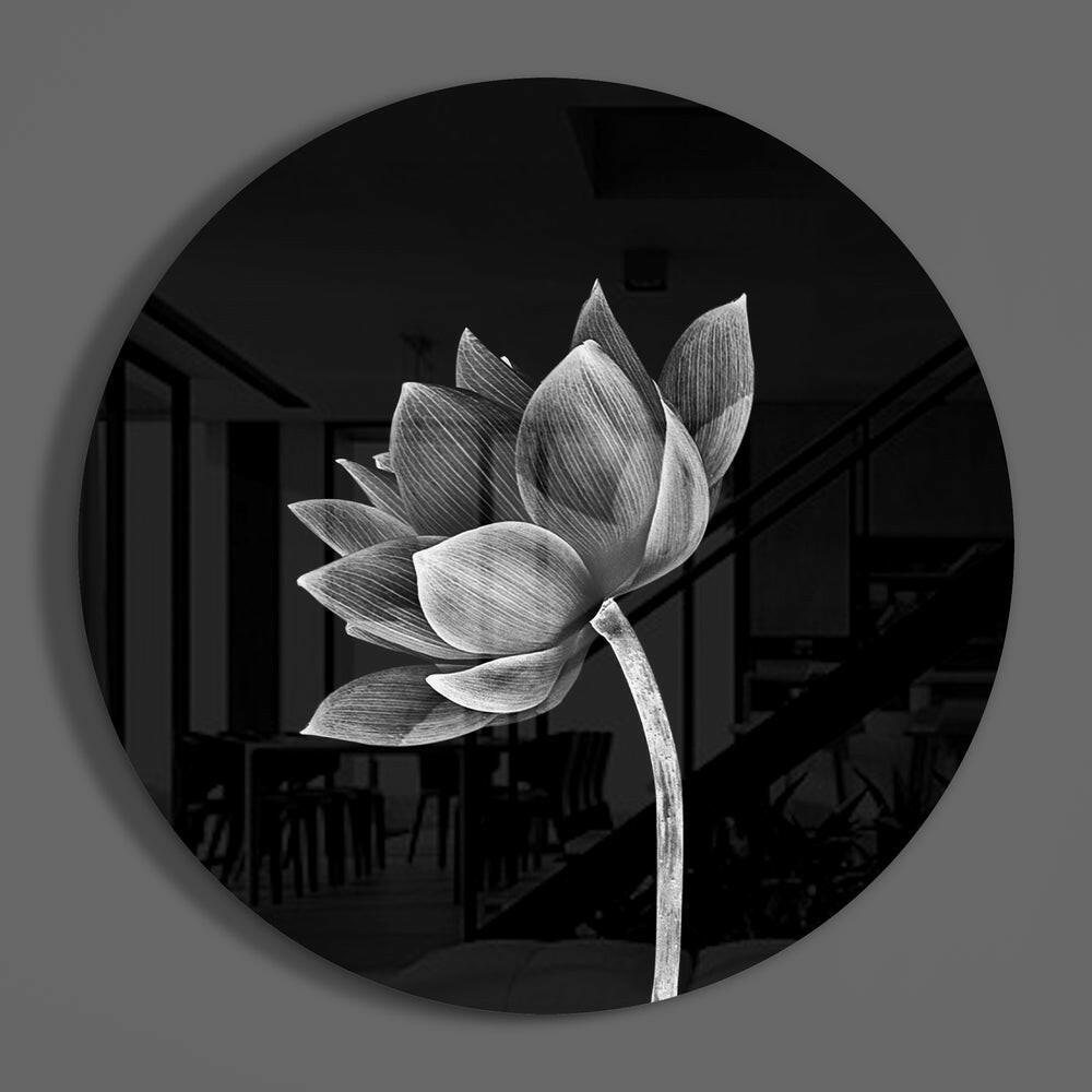 Monochrome lotus flower round glass wall art on a plain gray wall, glossy glass disc seen from the front