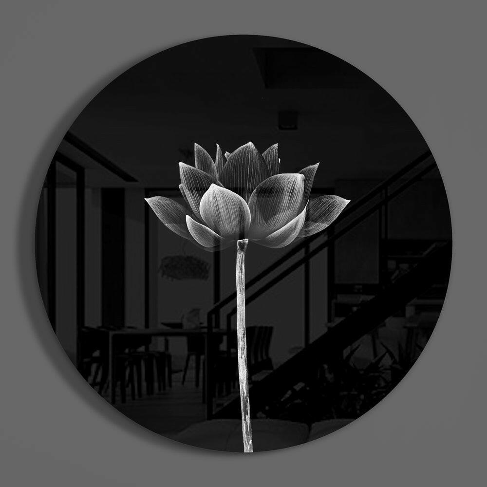 Monochrome lotus on black round glass wall art hanging on a plain gray wall