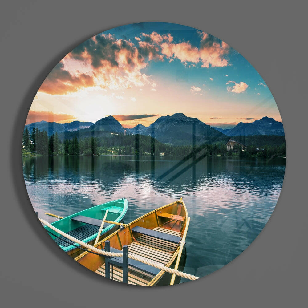 Rowboats on mountain lake round glass wall art on a plain gray wall