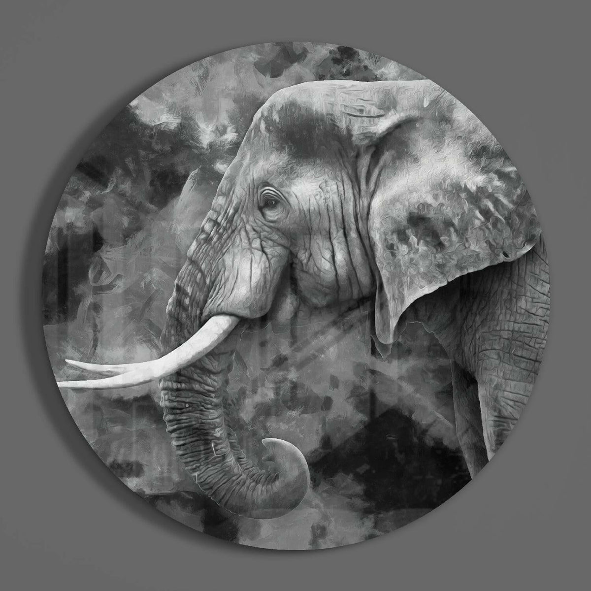 Black and white elephant profile round glass wall art on a plain gray wall, glossy glass disc seen from the front