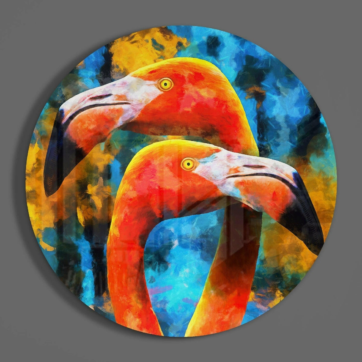 Twin orange flamingos on blue round glass wall art hanging on a plain gray wall