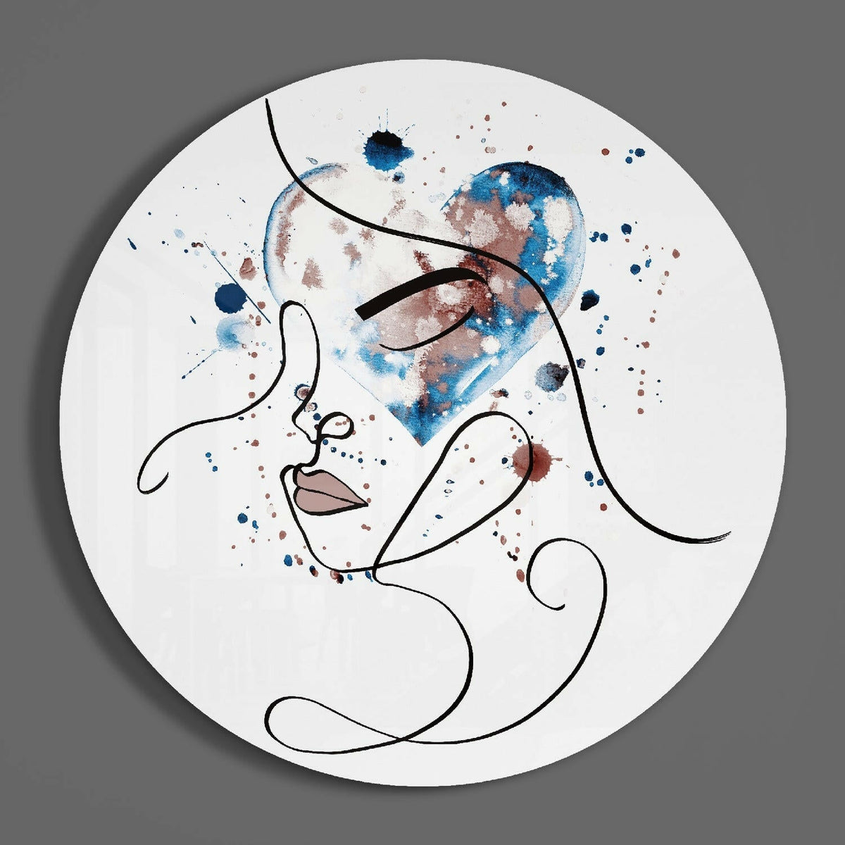 Line art face round glass wall art hanging on a plain gray wall