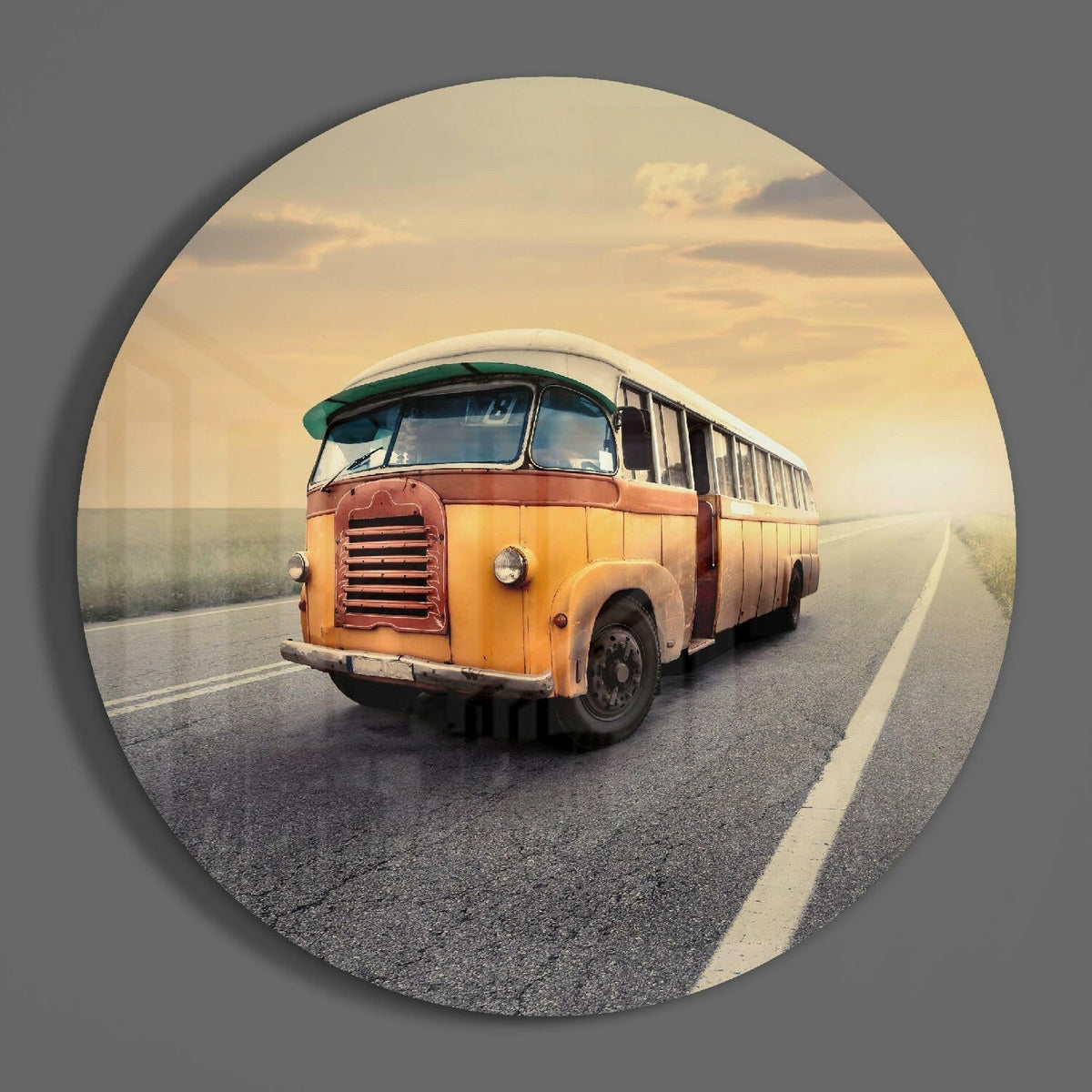 Yellow bus on an open road round glass piece shown on a plain gray wall