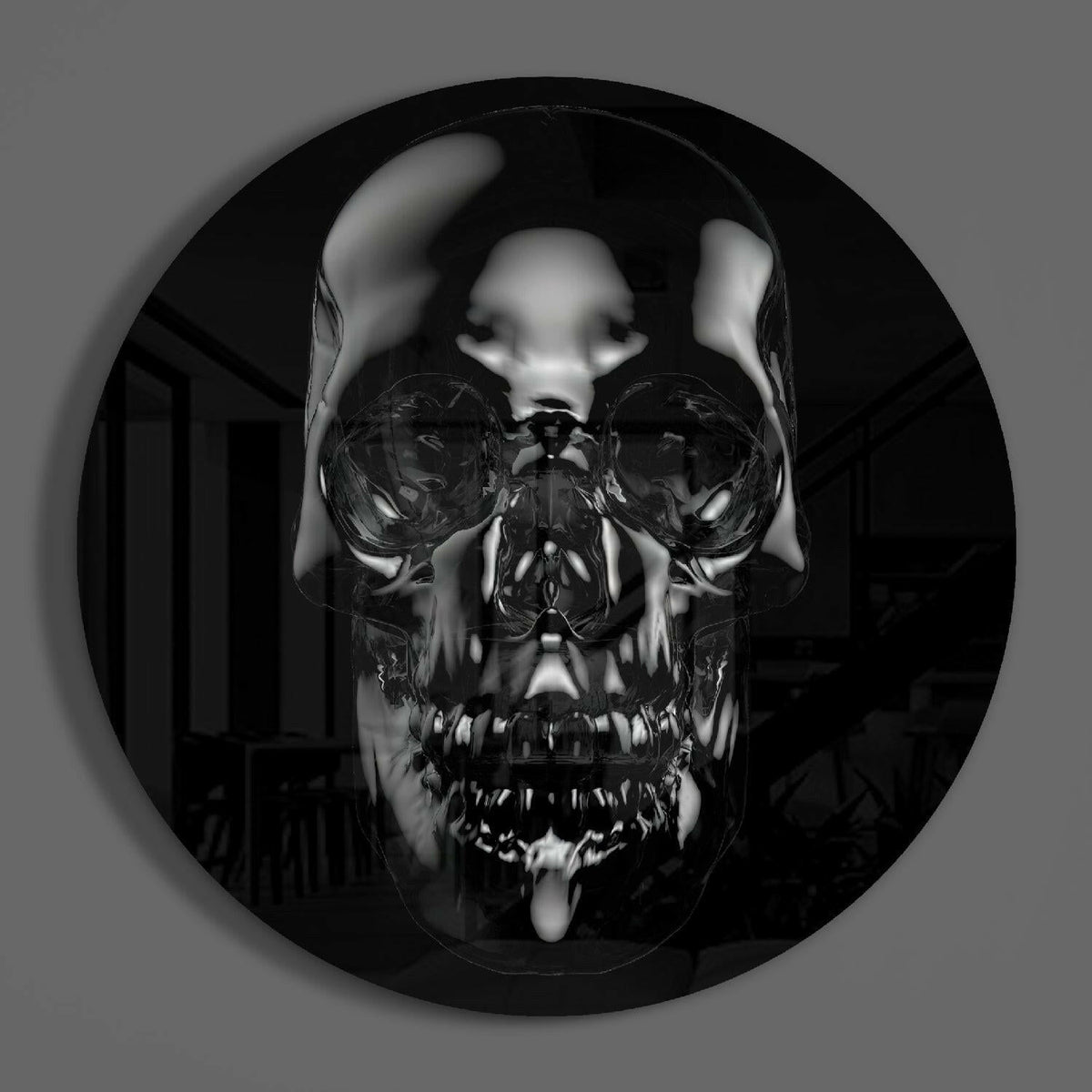 Black chrome skull round glass wall art on a plain gray wall