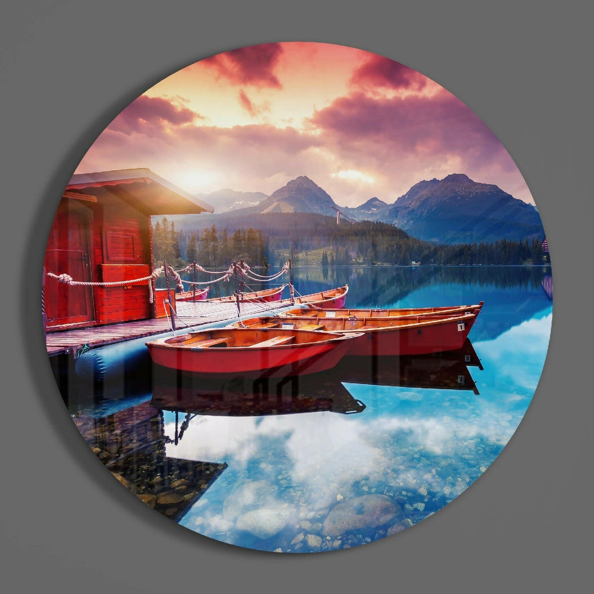 Mountain lake and red boats circle of glass on a plain gray wall