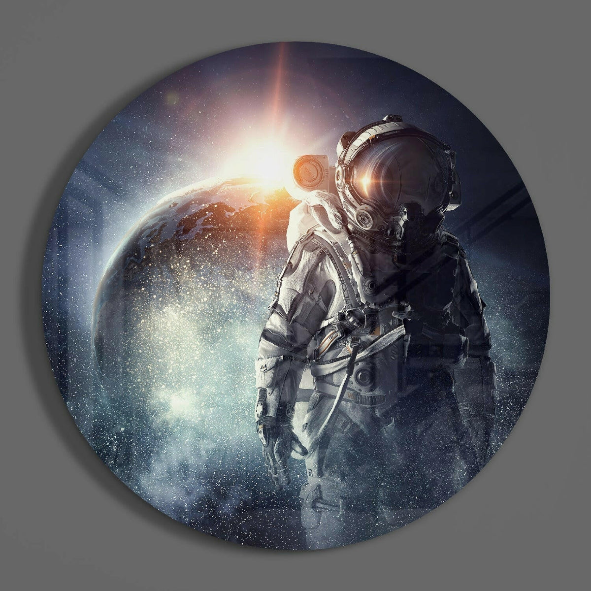 Astronaut round glass wall art hanging on a plain gray wall