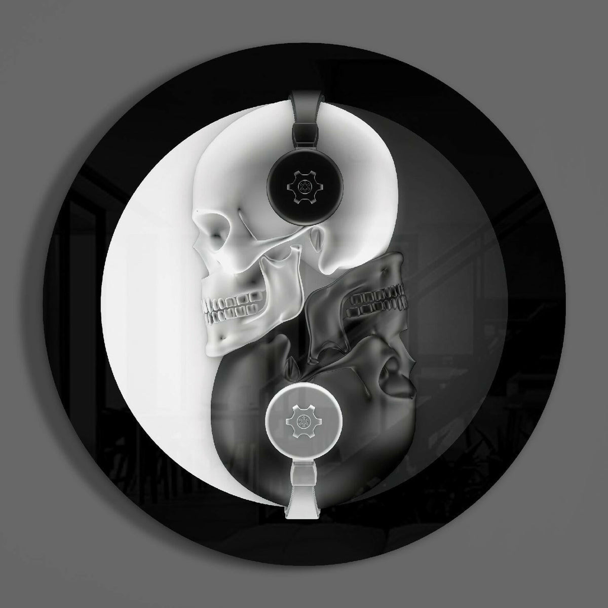 Yin yang skull round glass wall art on a plain gray wall, glossy black and white glass disc seen from the front