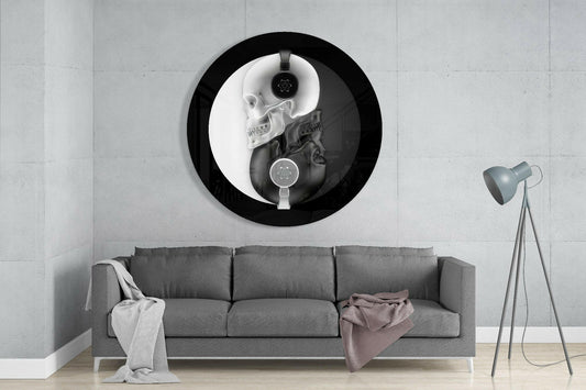 Yin yang skull round glass wall art above a gray sofa with draped throws on a pale concrete wall