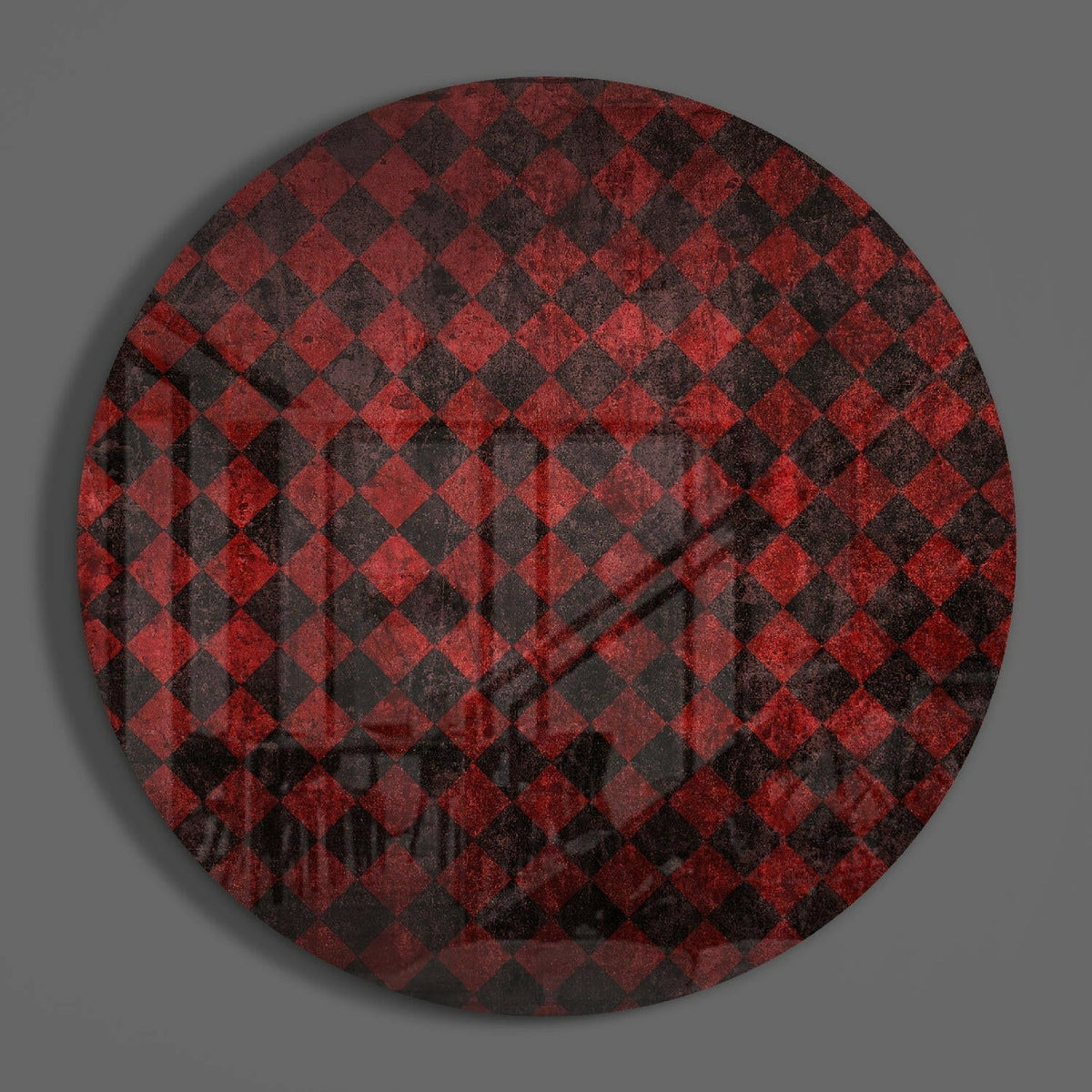 Red and black diamond circle of glass on a plain gray wall
