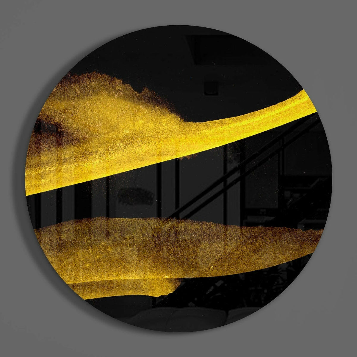 Gold bands round glass wall art hanging on a plain gray wall