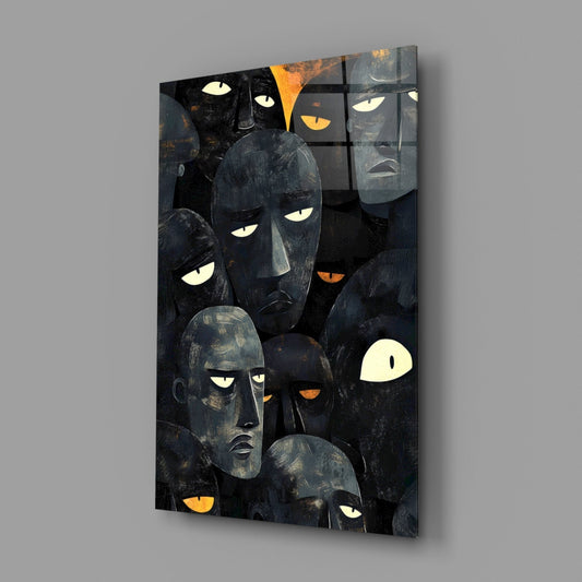 Charcoal mask faces glass wall art hanging on a plain gray wall