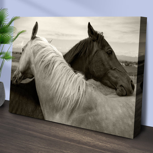 Sepia Horses Embracing canvas standing on a wood floor by a plant, angled side view