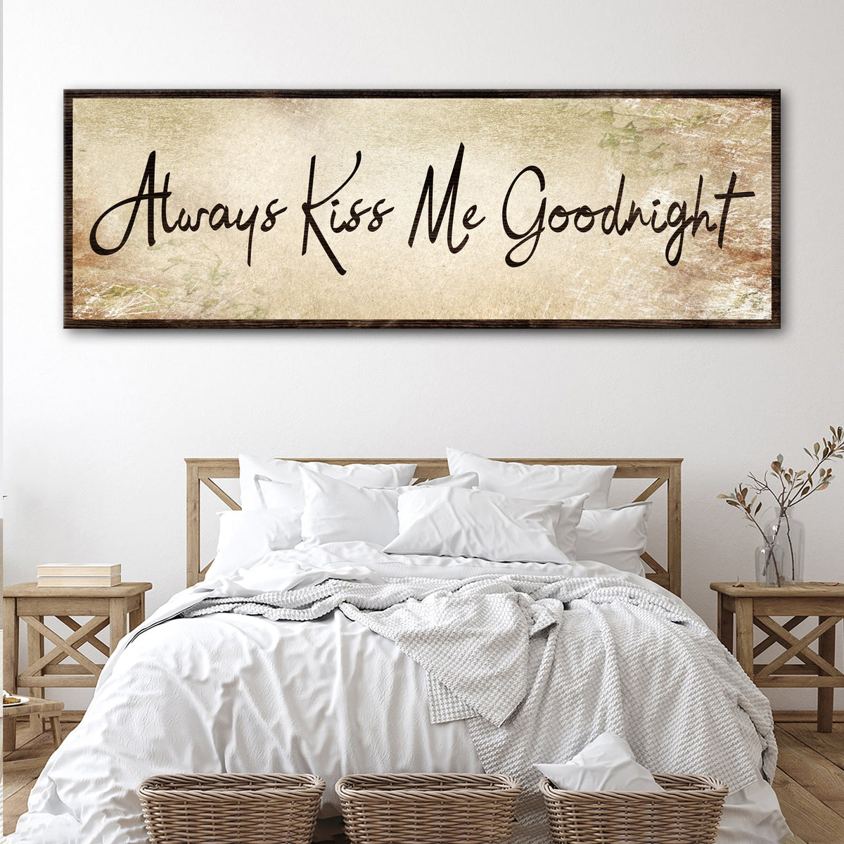 Always Kiss Me Goodnight canvas sign in the aged beige style, hung above a white bed with wooden nightstands
