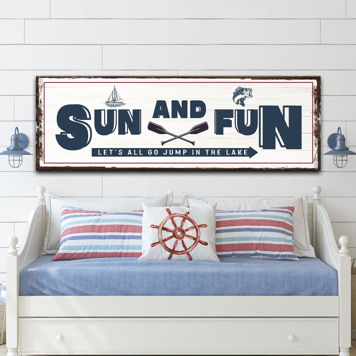 Sun and Fun canvas sign in the rustic brown border style, above a white daybed with striped pillows
