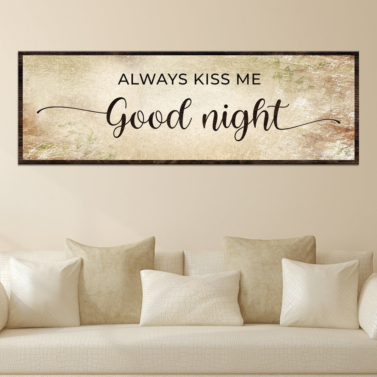 Always Kiss Me Good Night canvas sign in the warm beige style, hung above a cream sofa with pillows