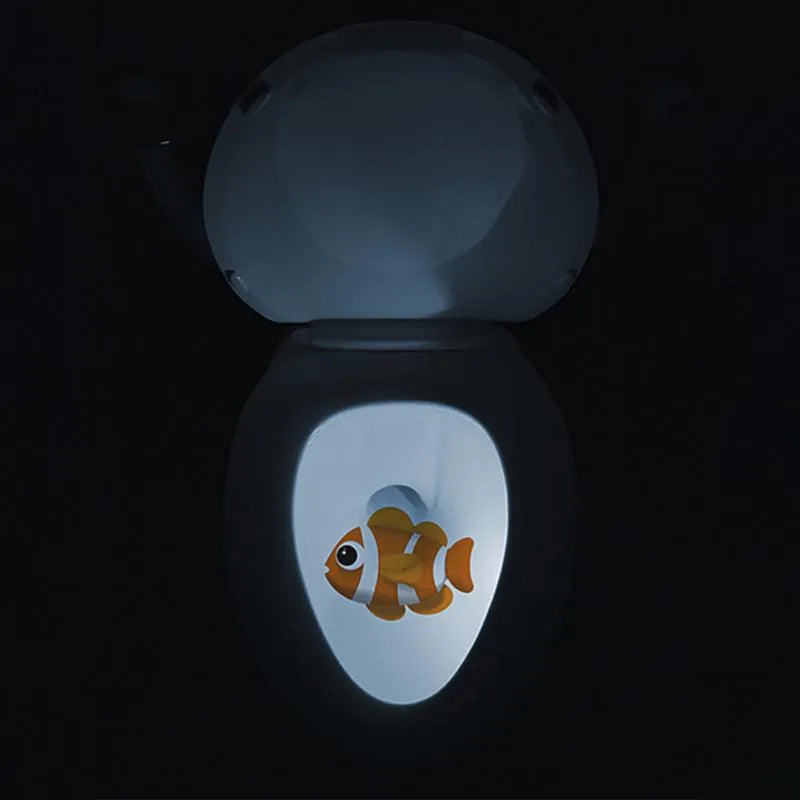 Toilet night light projecting cartoon fish pattern in darkness