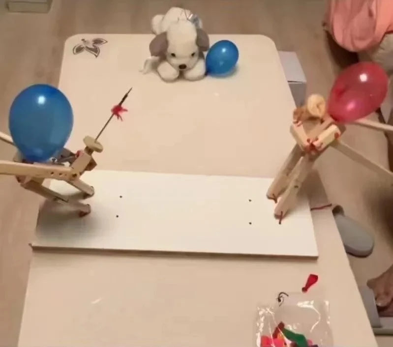 Two player party game showing red and blue balloon heads on wooden puppets