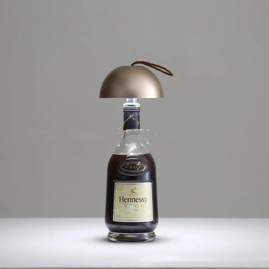 Wine bottle table lamp with metallic gold dome shade on glass bottle