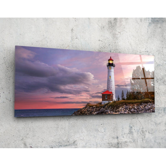 Lighthouse at dusk glass wall art on a pale concrete wall