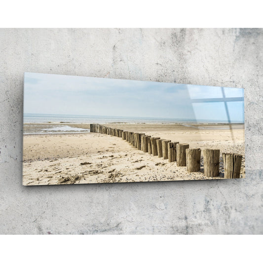 Weathered wood posts on the beach glass wall art on a pale concrete wall