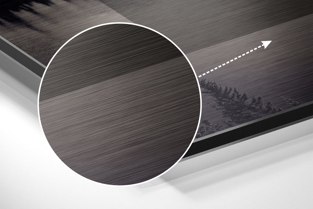 Magnified detail of the brushed metal grain showing through the present moment quote over a forest lake print