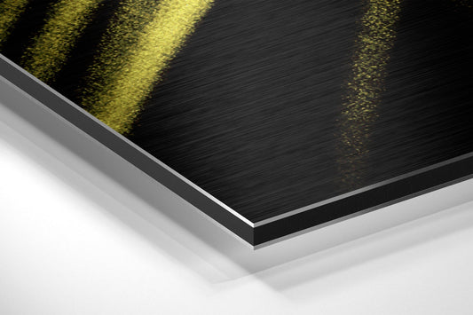 Yellow brushstroke brushed aluminum panel corner close-up showing the brushed metal grain