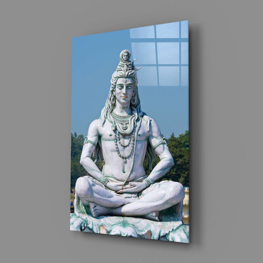 White Shiva statue in meditation glass wall art on a gray wall, angled to show the glossy front