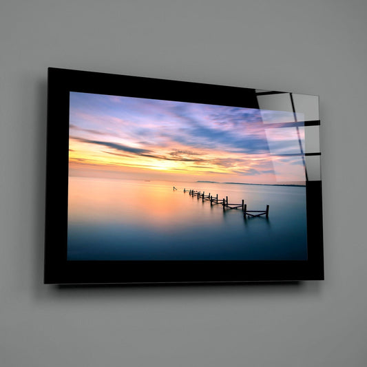 Pastel pier sunset glass wall art angled against a dark gray backdrop
