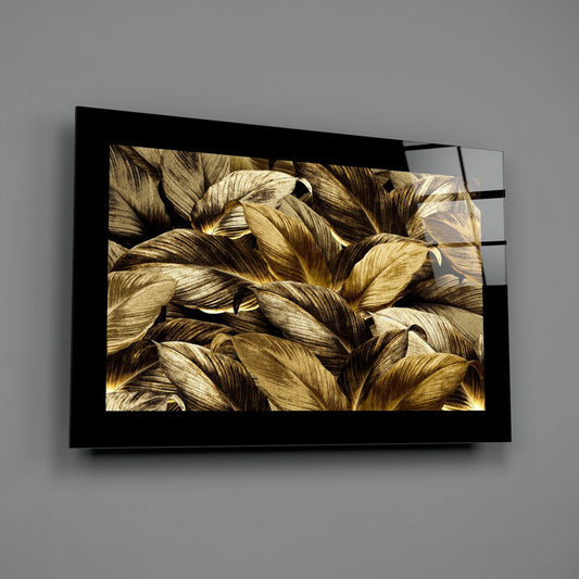 Golden leaves on black glass wall art with a wide black border on a gray wall