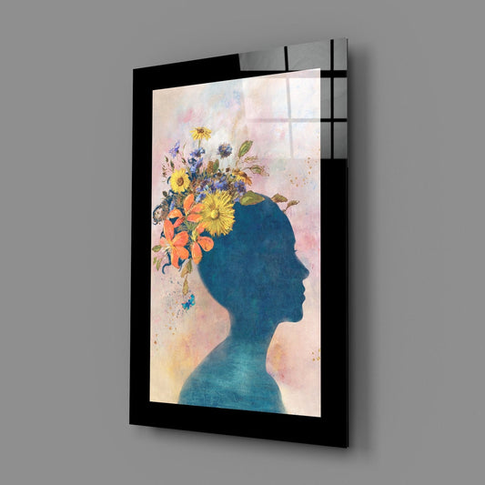 Woman silhouette with wildflowers glass wall art with a wide black border on a gray wall