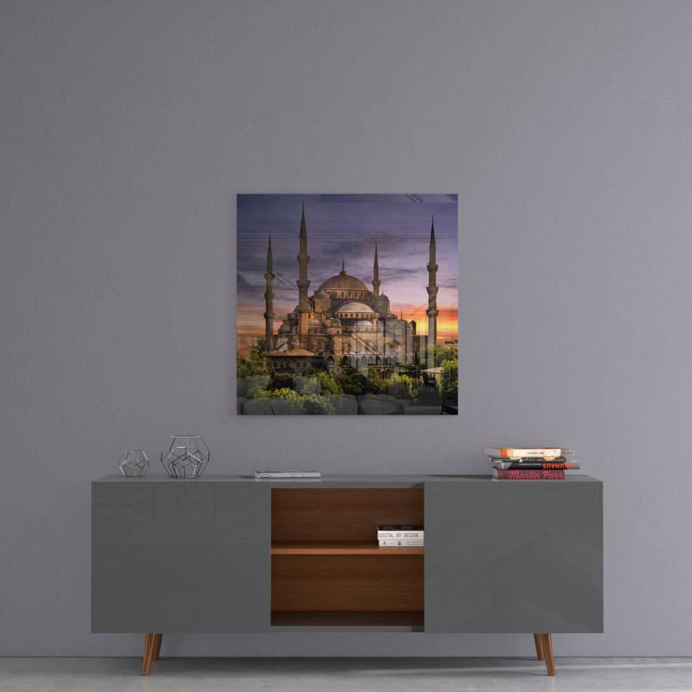Mosque and gardens at dusk glass wall art above a gray sideboard with a wooden center shelf